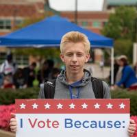 Student holding sign titled "I vote because: my vote matters"